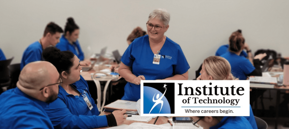 Woman standing speaking to people sitting at a table with IOT logo